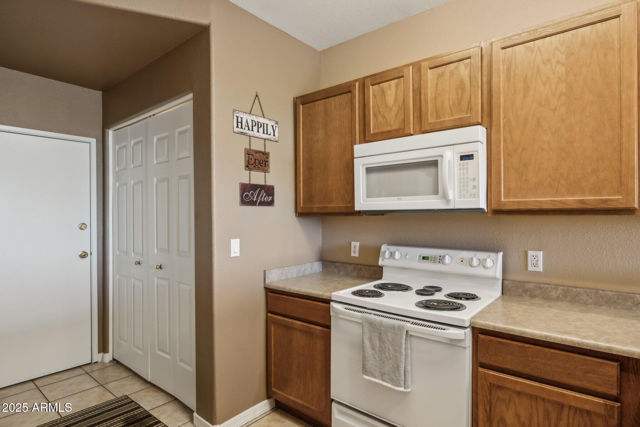 6535 East Superstition Springs Boulevard, Unit 109 Mesa, AZ 85206 - Photo 10 of 26 a kitchen with stainless steel appliances white cabinets and a stove top oven