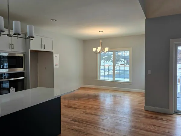 a kitchen with stainless steel appliances a refrigerator and a wooden floor