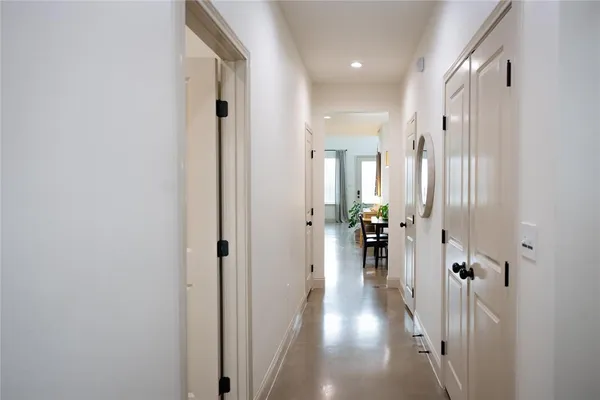 a view of a hallway with wooden floor and living room