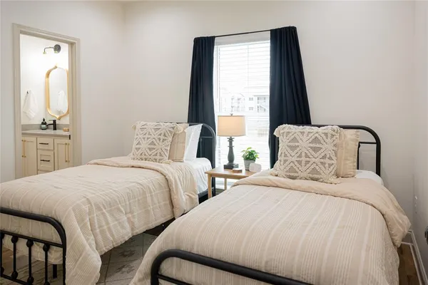 a bedroom with two beds and painting on the dresser