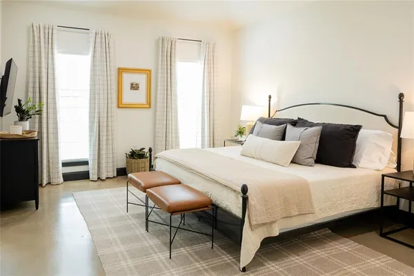 a bedroom with a bed chair and window