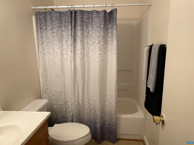 a bathroom with a toilet and a shower curtain