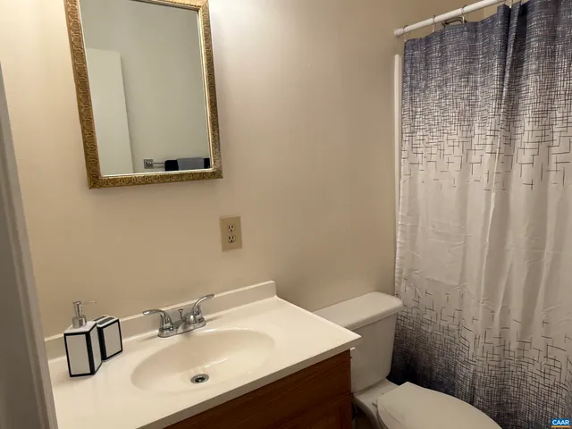 a bathroom with a sink a toilet and mirror