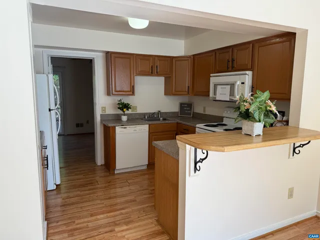 a kitchen with stainless steel appliances a sink a stove a refrigerator a microwave a sink and cabinets