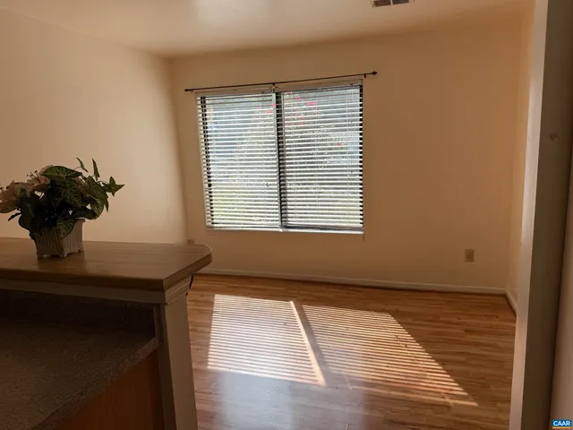 a view of a room with a window and wooden floor