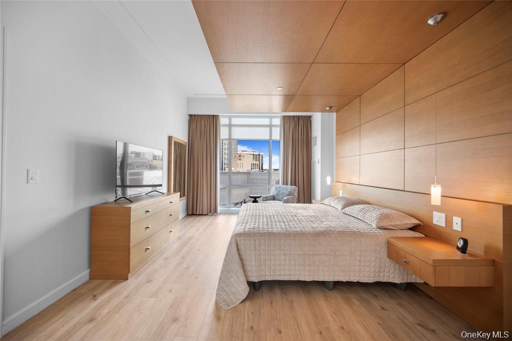 1 Renaissance Square, Unit 10F White Plains, NY 10601 - Photo 11 of 27 a bedroom with a bed and wooden floor