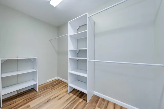 a view of walk in closet with empty racks