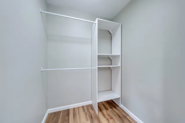 a view of walk in closet with empty racks