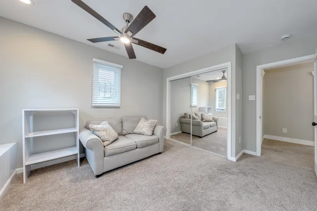 a living room with furniture and a ceiling fan