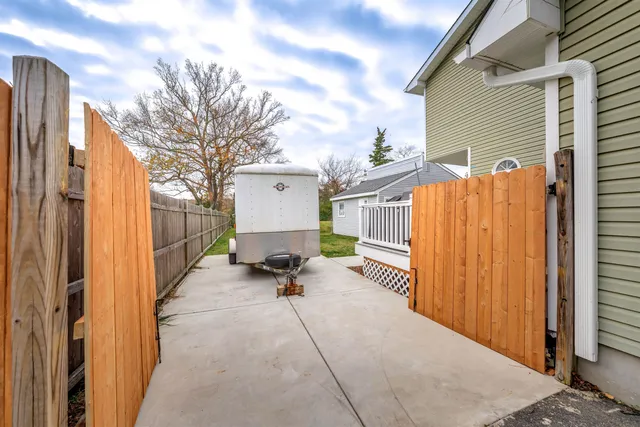 a view of a patio with a table and chairs and couches with wooden fence