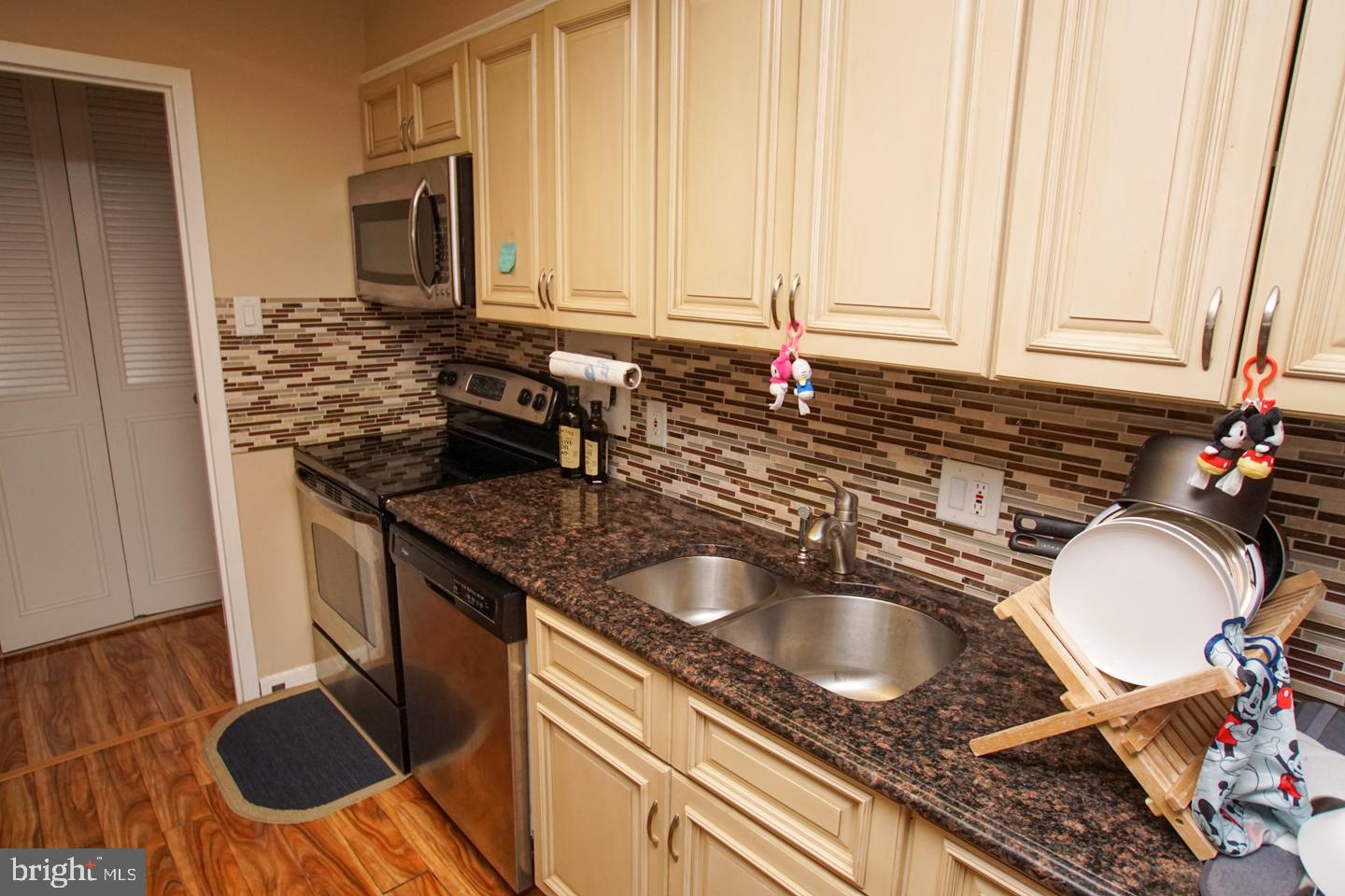 a kitchen with granite countertop a sink a stove and a refrigerator