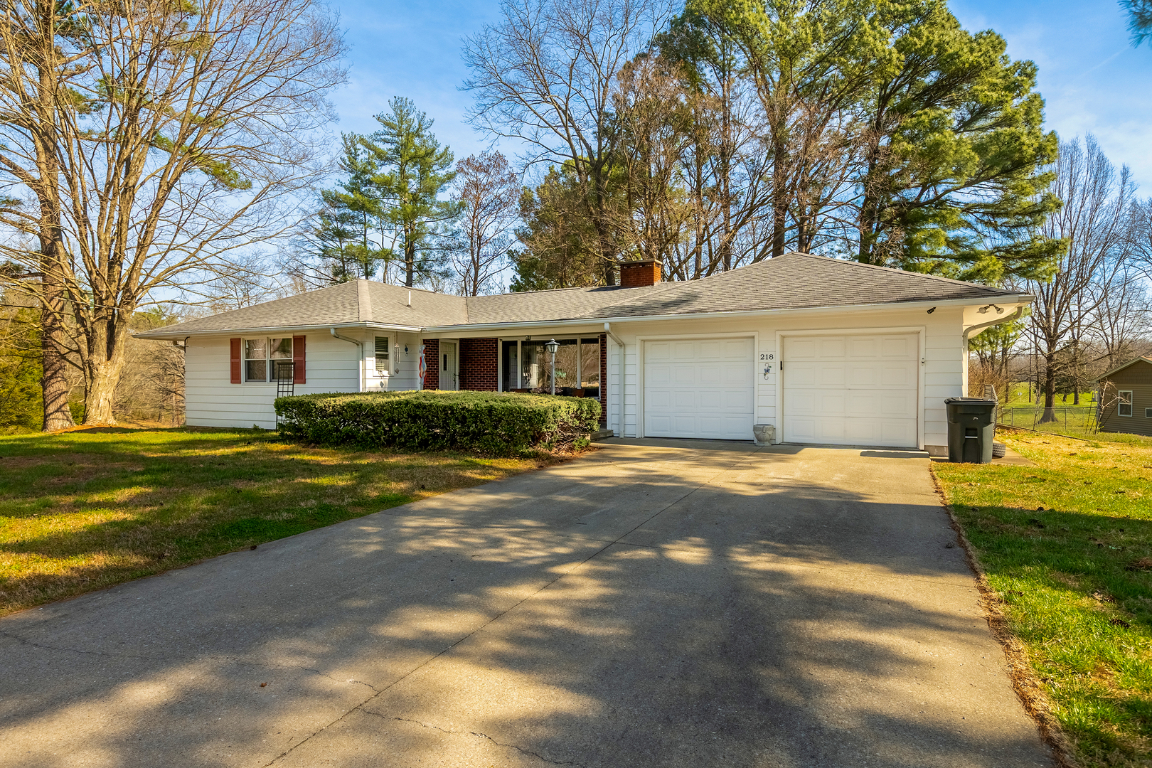 a view of a house with a yard covered with trees
