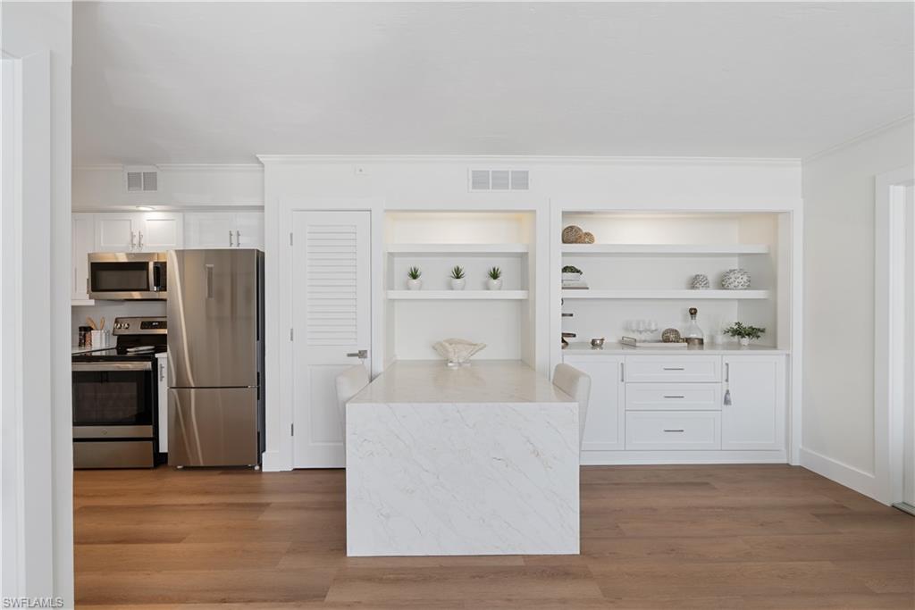 975 9th Avenue South, Unit 1 Naples, FL 34102 - Photo 22 of 34 a view of kitchen with white cabinets and stainless steel appliances