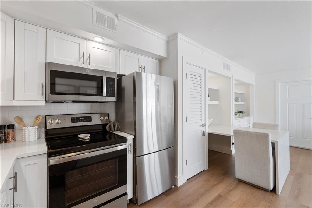 975 9th Avenue South, Unit 1 Naples, FL 34102 - Photo 29 of 34 a kitchen with stainless steel appliances a refrigerator stove and microwave