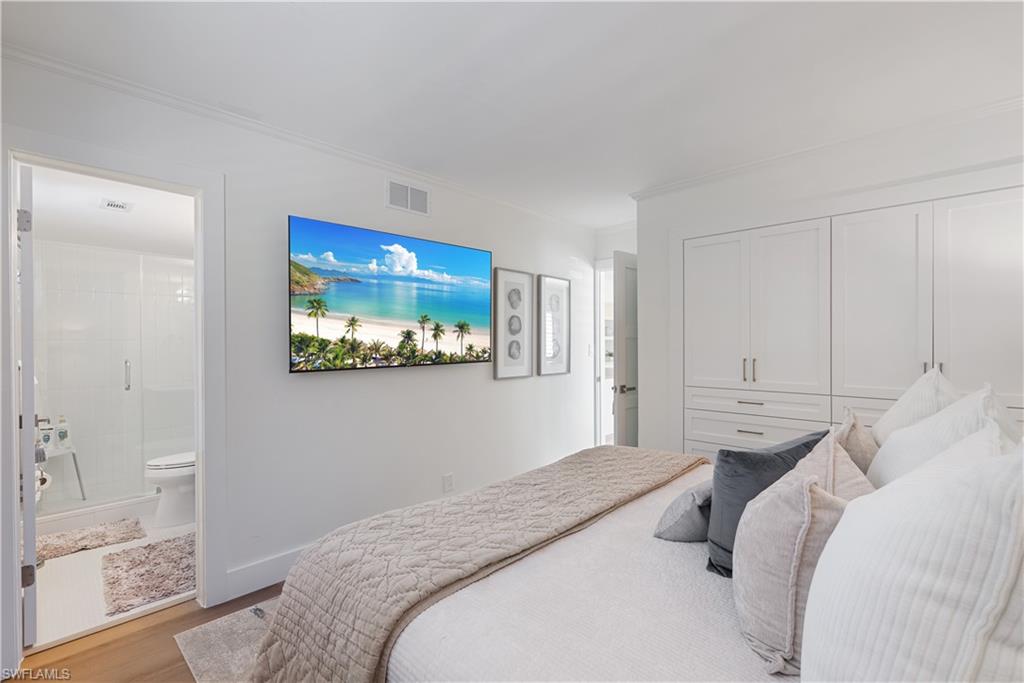 975 9th Avenue South, Unit 1 Naples, FL 34102 - Photo 33 of 34 a bedroom with a bed and a view of bathroom