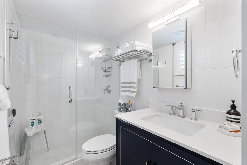 975 9th Avenue South, Unit 1 Naples, FL 34102 - Photo 34 of 34 a bathroom with a sink a toilet a mirror and shower