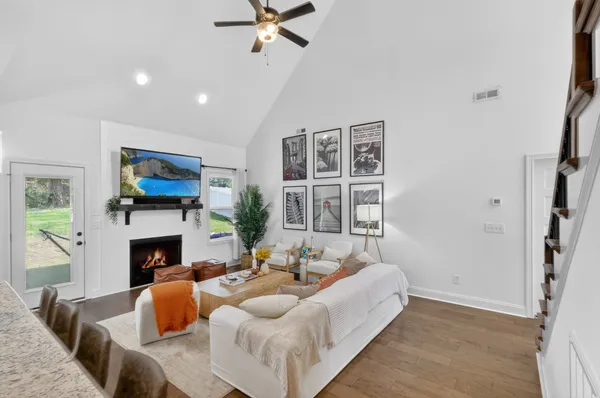 a living room with furniture a fireplace and a flat screen tv