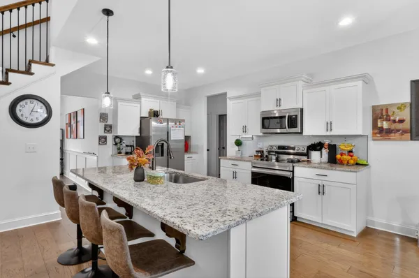 a kitchen with kitchen island a stove a table and chairs in it