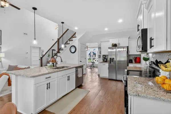a kitchen with a sink a stove and chairs