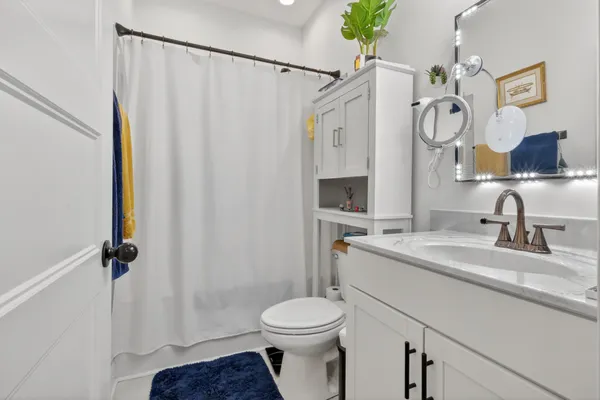 a bathroom with a granite countertop sink toilet and shower