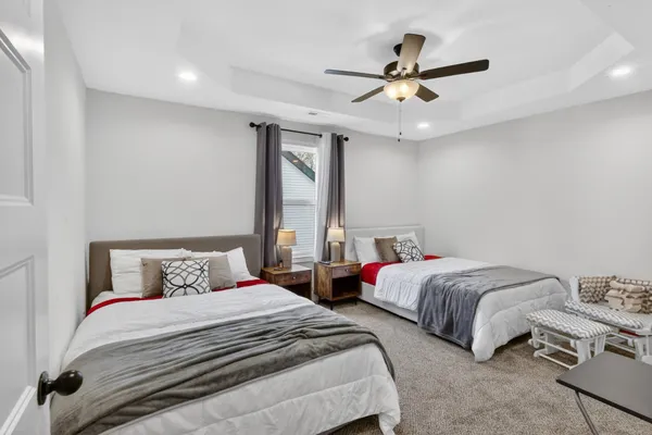 a bedroom with two beds and ceiling fan