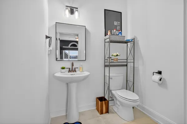 a bathroom with a toilet a sink and mirror