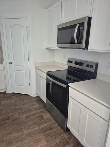 a kitchen with cabinets and steel appliances