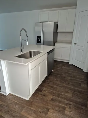 a kitchen with stainless steel appliances a sink and a hard wood floor