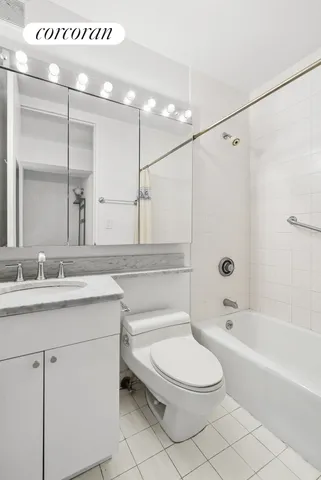 a bathroom with a granite countertop sink a toilet a mirror and bathtub