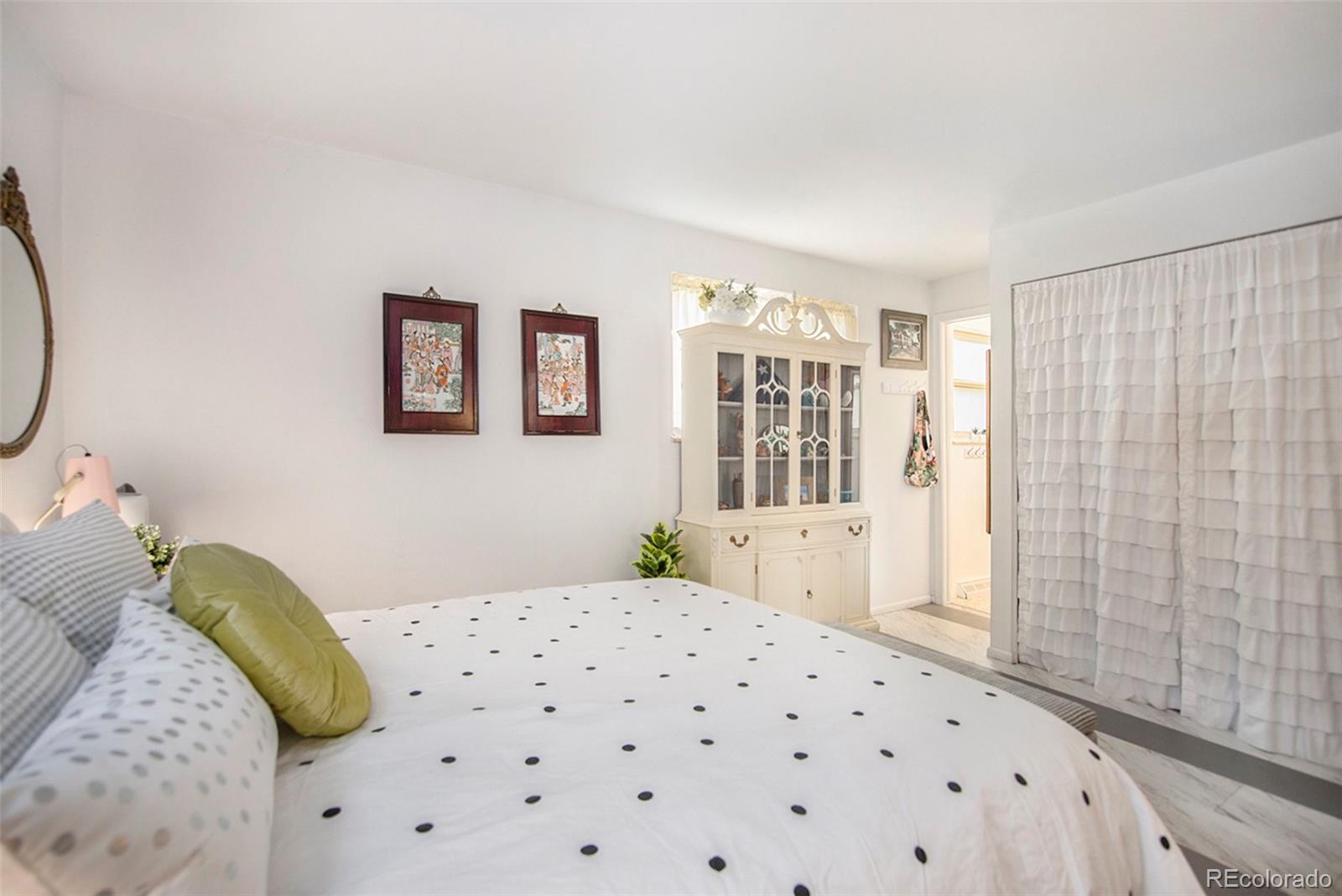6180 South Ash Circle West Centennial, CO 80121 - Photo 12 of 23 a bedroom with a bed and a painting on the wall