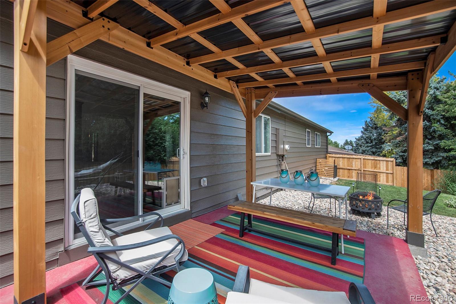6180 South Ash Circle West Centennial, CO 80121 - Photo 19 of 23 a backyard of a house with barbeque oven table and chairs