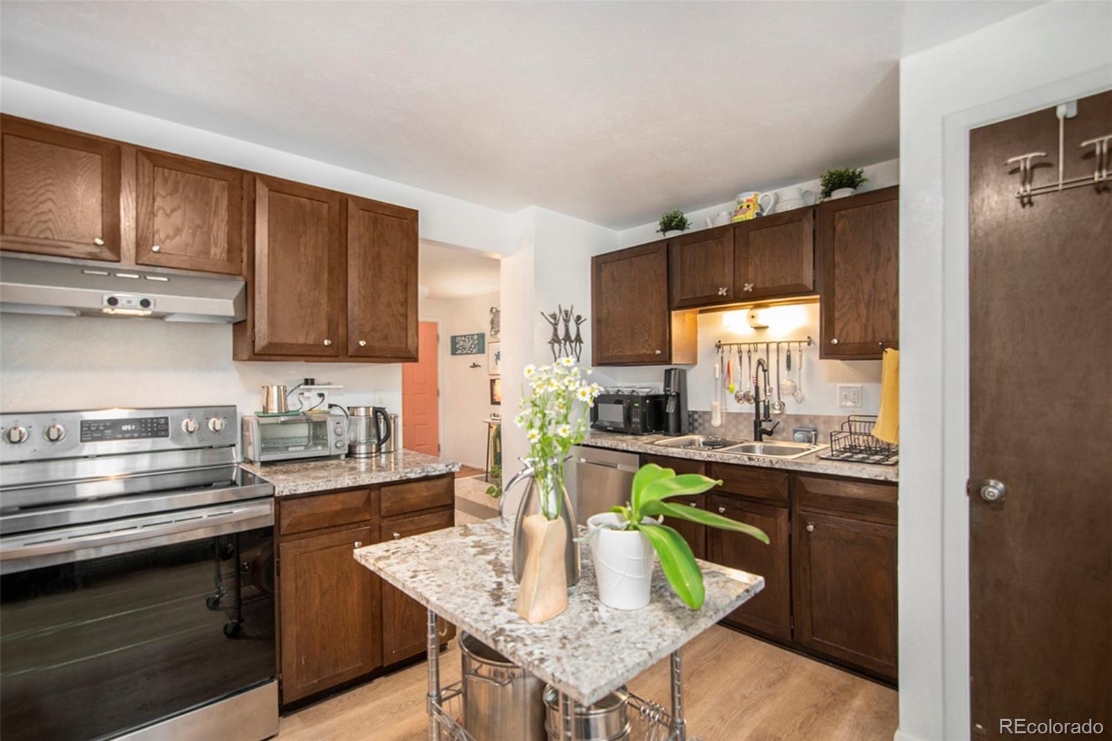 6180 South Ash Circle West Centennial, CO 80121 - Photo 6 of 23 a kitchen with a sink a stove cabinets and wooden floor