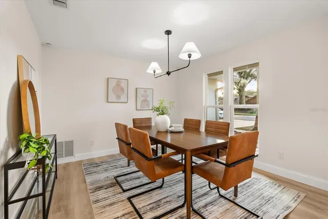 a large kitchen with stainless steel appliances a large window and a wooden floors