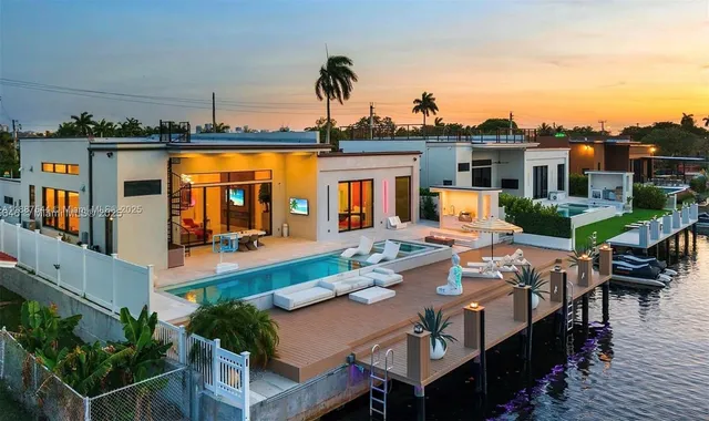 a view of a patio with couches and table and chairs with wooden floor and fence