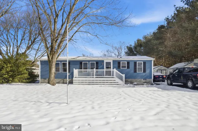 a front view of a house with a yard covered in snow
