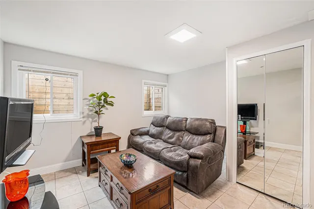 a living room with furniture a flat screen tv and a window