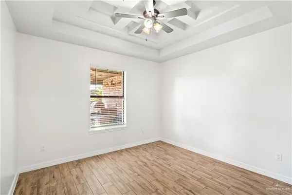 an empty room with a window and a fan