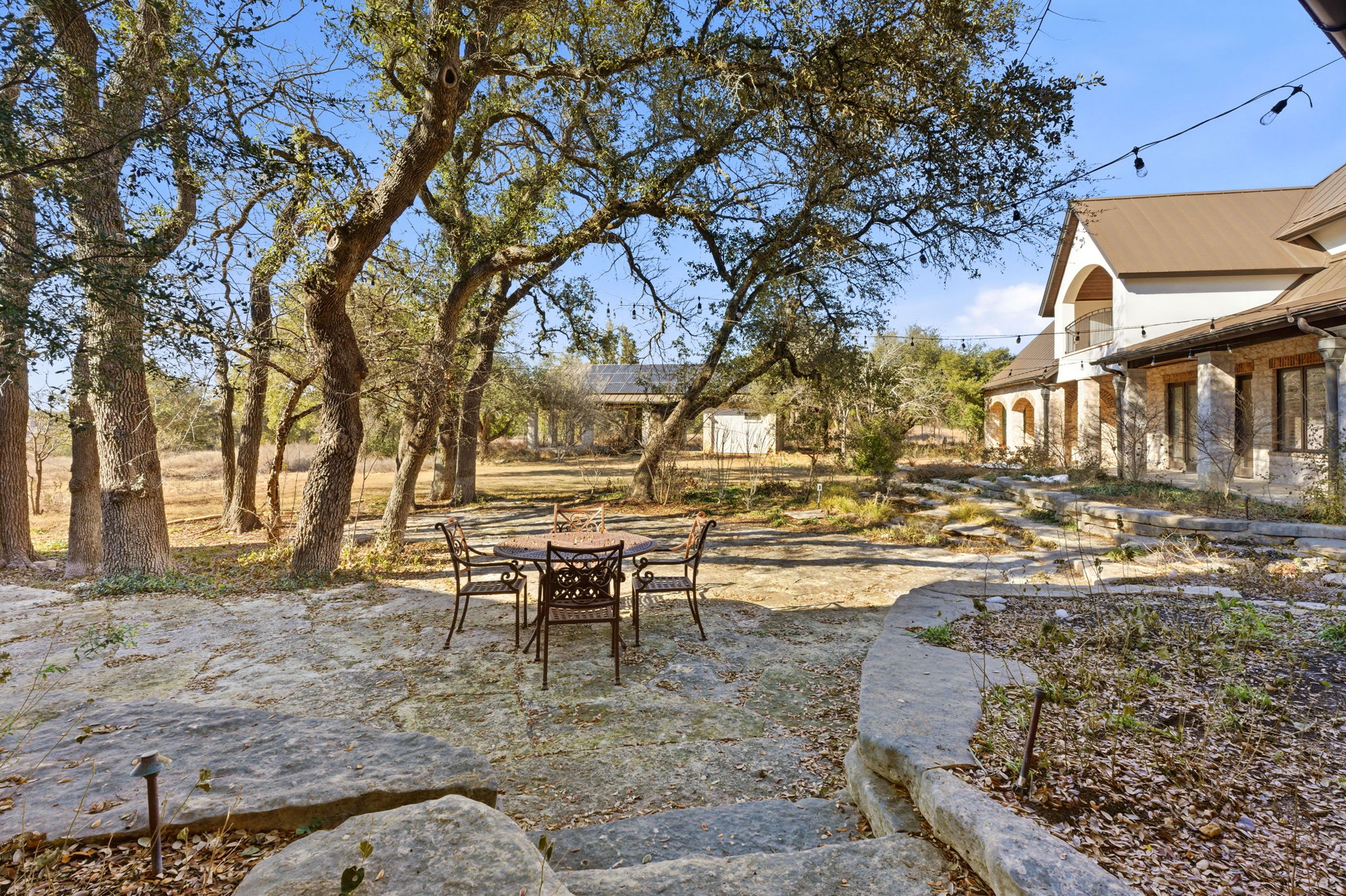 16400 Hamilton Pool Road Austin, TX 78738 - Photo 25 of 37 a view of a building with a yard and sitting area