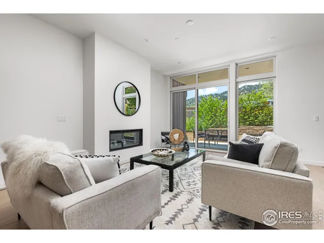 a living room with furniture a table and a large window