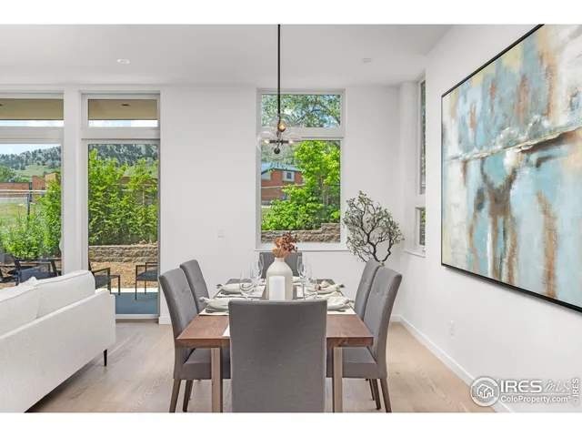 a kitchen with stainless steel appliances a refrigerator a stove a sink dishwasher and white cabinets with wooden floor