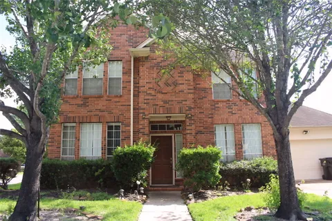 a front view of a house with yard and green space