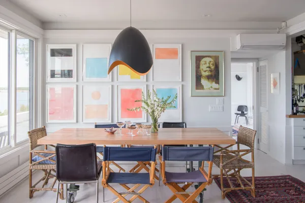 a view of roof deck with table and chairs a barbeque with wooden floor and fence