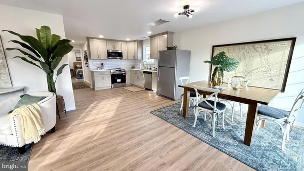a view of a dining room with furniture a rug and wooden floor