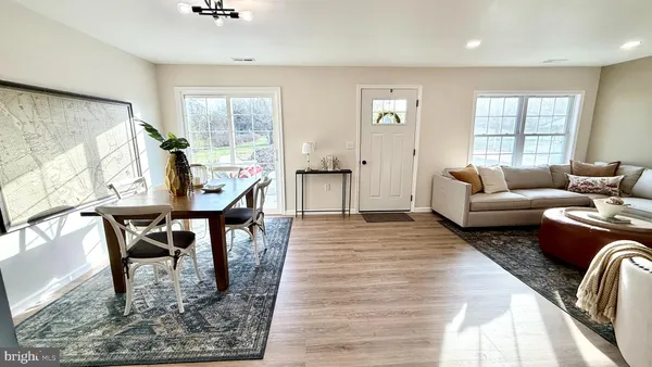 a living room with furniture a dining table and a large window