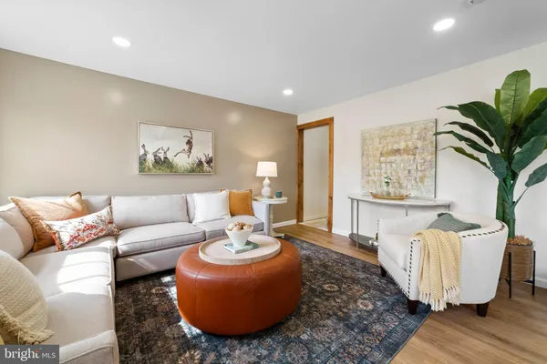a living room with furniture flowerpot and wooden floor