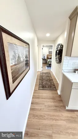 a view of a hallway with wooden floor and workspace