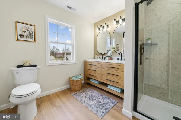 a bathroom with a toilet sink vanity and mirror