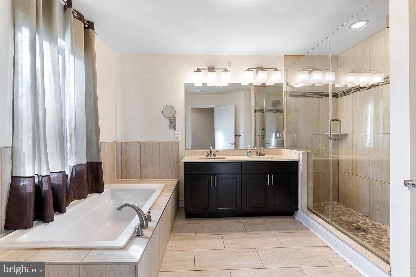 1347 South 20th Street, Unit A Philadelphia, PA 19146 - Photo 6 of 21 a bathroom with a tub sink and mirror