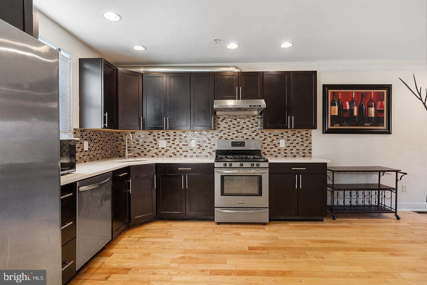 1347 South 20th Street, Unit A Philadelphia, PA 19146 - Photo 9 of 21 a kitchen with stainless steel appliances kitchen island granite countertop a stove and a sink