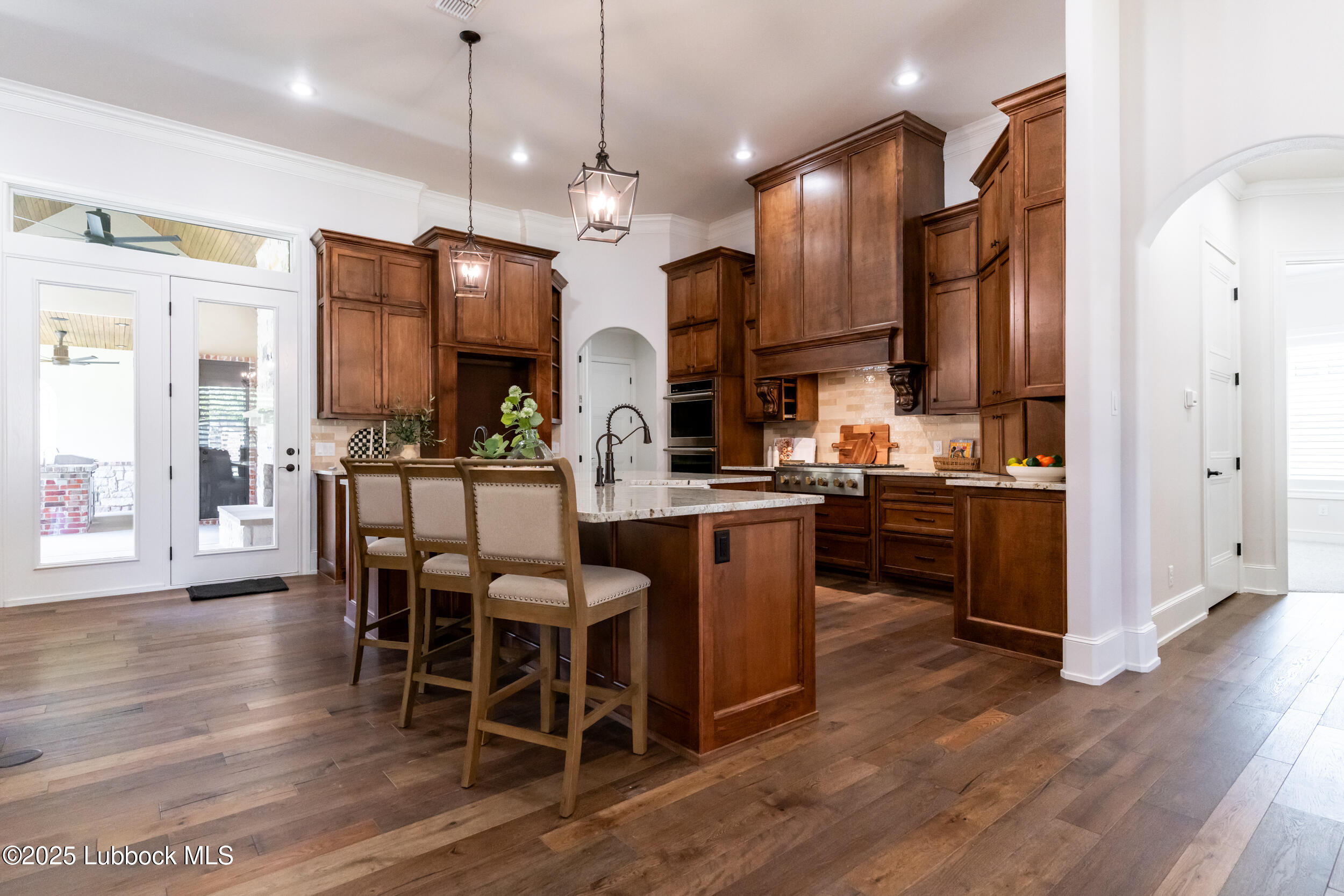 3913 106th Street Lubbock, TX 79423 - Photo 16 of 80 a kitchen with stainless steel appliances kitchen island granite countertop a table chairs and a refrigerator